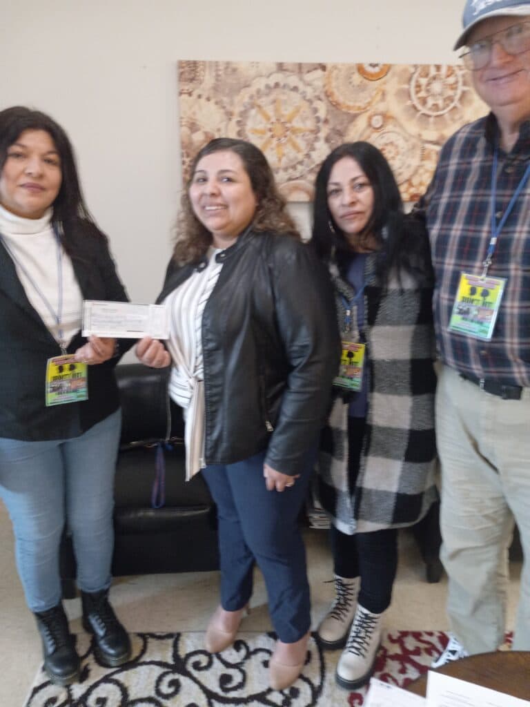 Volunteers make a contribution to the director of ACTS domestic violence shelter in Dumfries, Virginia.