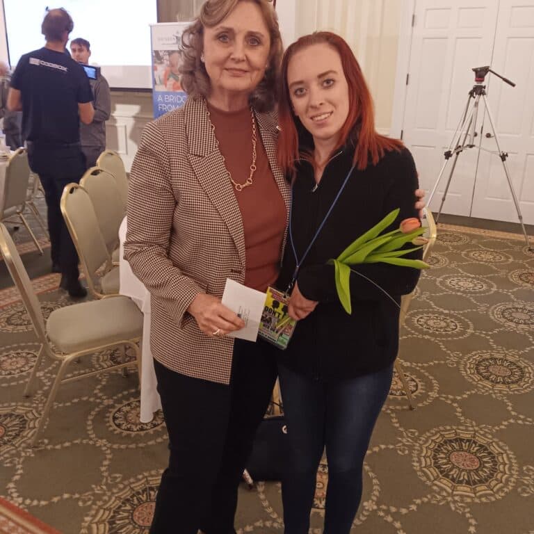 Mrs. Alice of the Brisbane homeless center encourages a volunteer at a sponsored breakfast.